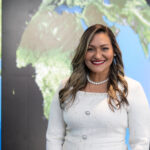 Dr. Yaítza Luna-Cruz: Program Executive at NASA Yaíta smiles broadly at the camera wearing a white dress with a pearl necklace. Her hair is long with curls and she