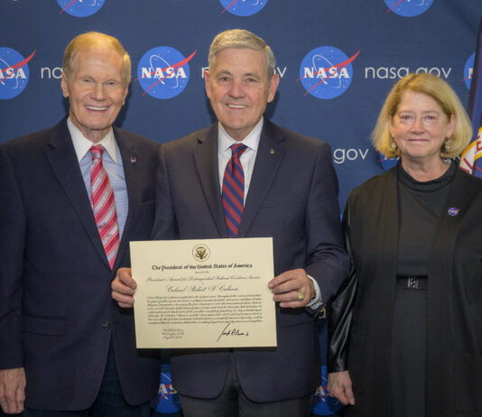 Ex-NASA Astronaut Bob Cabana Honored with Prestigious Civilian Award Nelson, Cabana, and Melroy are side by side, smiling, in front of a background with NASA logos, with Cabana holding the award certificate.