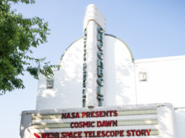 Greenbelt Cinema Hosts NASA’s “Cosmic Dawn” Screening Event 10 people stand in a line at a movie theater. About half of the people are standing under the movie marquee, which reads