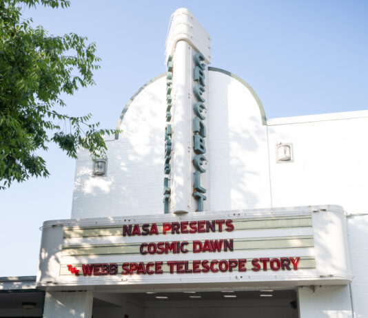 Greenbelt Cinema Hosts NASA’s “Cosmic Dawn” Screening Event 10 people stand in a line at a movie theater. About half of the people are standing under the movie marquee, which reads