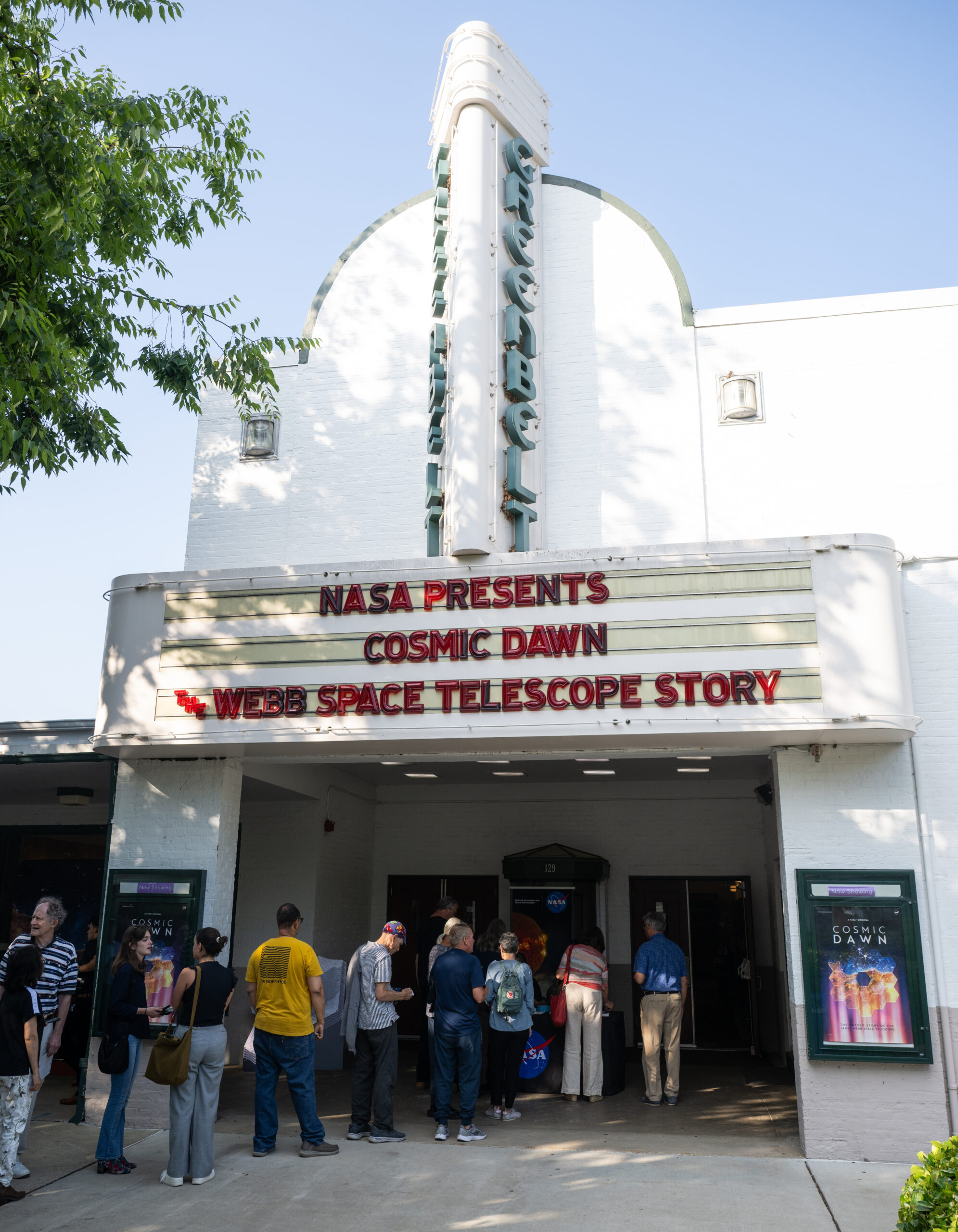 nhq202506110001orig.jpg 10 people stand in a line at a movie theater. About half of the people are standing under the movie marquee, which reads