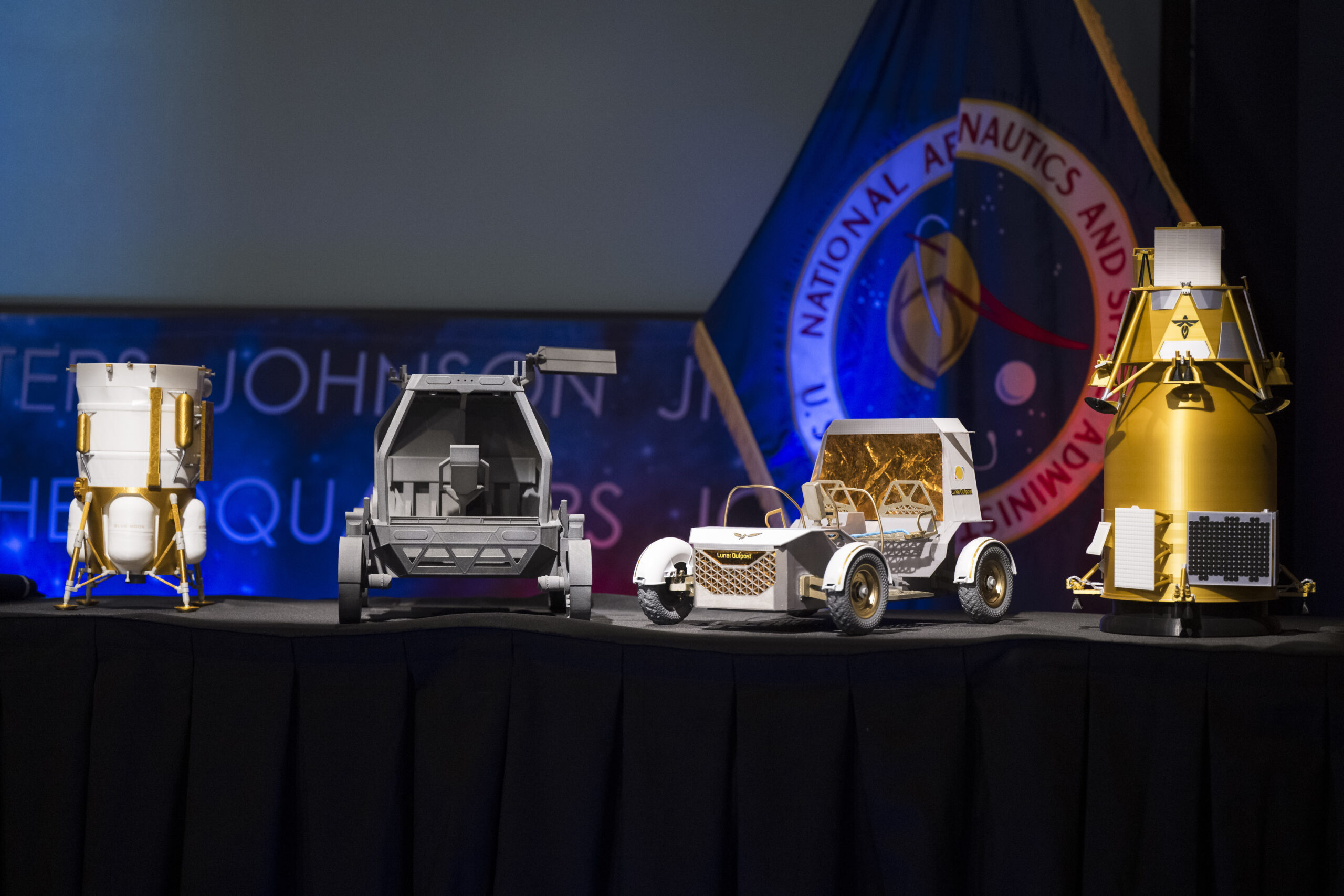 Current image: From left to right, models of the Blue Origin Mark 1 Lunar Lander, Astrolab Crewed Lunar Rover, Lunar Outpost Pegasus rover, and the Firely Elytra Dark orbiter are seen at the conclusion of a news conference to discuss Moon Base, a long-term lunar exploration and infrastructure initiative designed to enable sustained human presence and expanded scientific and commercial activity at the lunar South Pole, Tuesday, May 26, 2026, at the Mary W. Jackson NASA Headquarters building in Washington. Photo Credit: (NASA/Aubrey Gemignani)