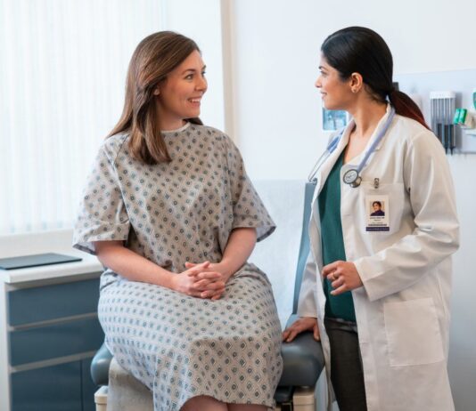 One Year of DAX Copilot: Enhancing Clinician-Patient Relationships A medical clinician talking with a patient in an exam room. patient