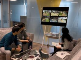 Microsoft Blog: Reaching a New Milestone Three people playing a video game on a large screen.