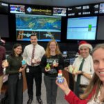 NASA’s Holiday Cookies: A Sweet Mission from Houston Six flight controllers stand in Johnson Space Center