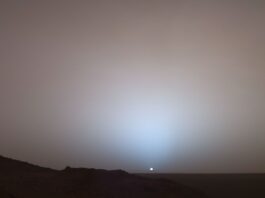 Mars Sunset Captured by NASA The Sun, a small white dot, sets in this photo from Mars. The sky is dusty and slightly red.
