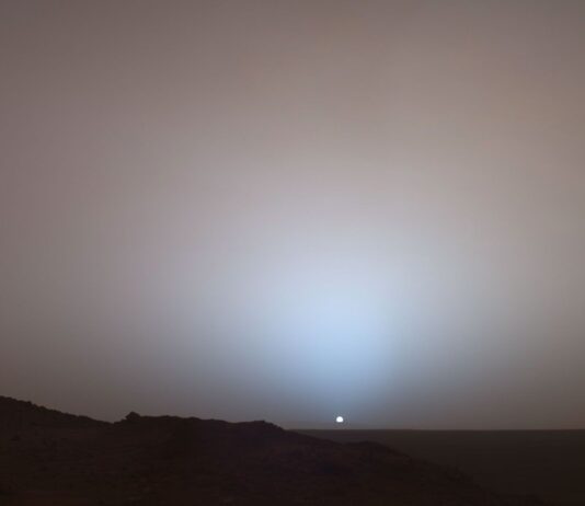 Mars Sunset Captured by NASA The Sun, a small white dot, sets in this photo from Mars. The sky is dusty and slightly red.