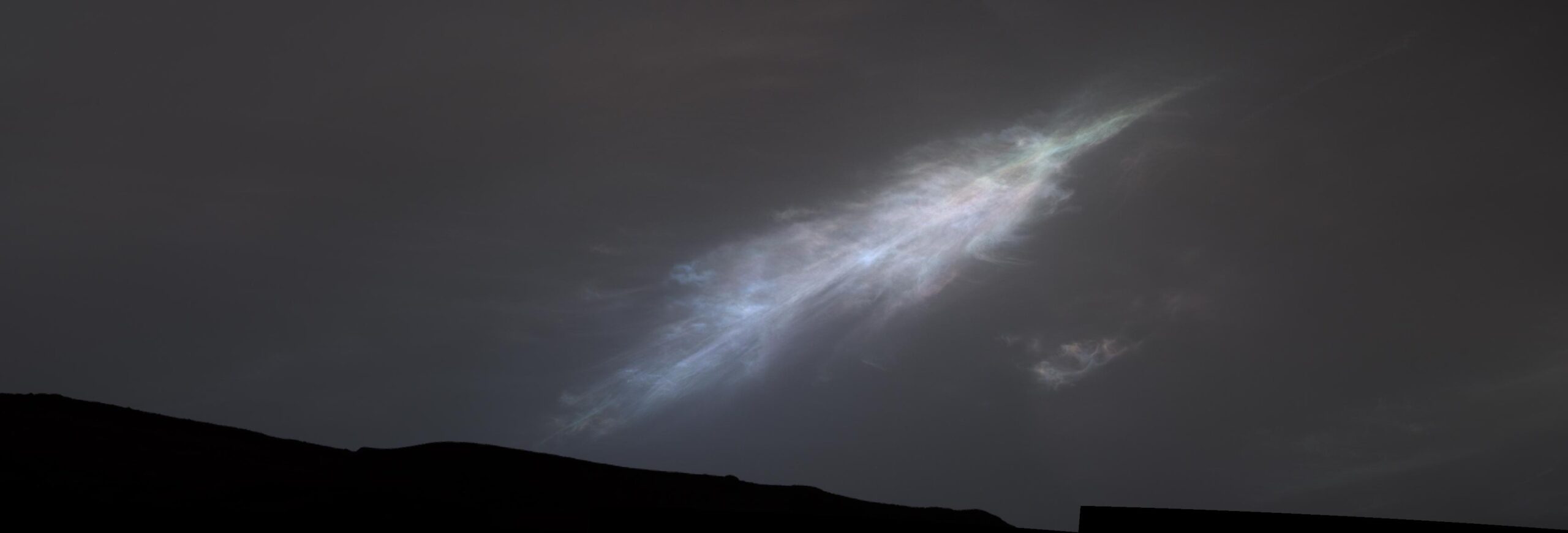 pia25740orig.jpg A shining, feather-shaped cloud in the dark gray Martian sky. The cloud is white, with a faint rainbow tint.