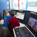 NASA Exhibit Lets You Experience Being a Test Conductor A pair of young visitors to INFINITY Science Center