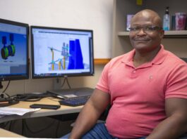 Robert Williams Joins Groundbreaking NASA Project Robert Williams, wearing a coral polo styled shirt, poses for a portrait while seated at his workstation
