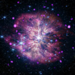 NASA Telescopes Capture Black Hole’s Musical Prelude and Fugue At the center of the composite image of WR124 is the large gleaming star in white and pale blue. The star sits at the heart of a mottled pink and gold cloud, its long diffraction spikes extending to the outer edges. Also residing in the cloud are other large gleaming stars, glowing hot-pink dots, and tiny specks of blue and white light.