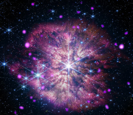 NASA Telescopes Capture Black Hole’s Musical Prelude and Fugue At the center of the composite image of WR124 is the large gleaming star in white and pale blue. The star sits at the heart of a mottled pink and gold cloud, its long diffraction spikes extending to the outer edges. Also residing in the cloud are other large gleaming stars, glowing hot-pink dots, and tiny specks of blue and white light.