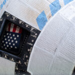 NASA Announces Starliner Return, News Conference Coverage A picture of the American flag inside the window of Boeing