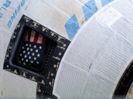 NASA Announces Starliner Return, News Conference Coverage A picture of the American flag inside the window of Boeing