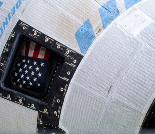 NASA Announces Starliner Return, News Conference Coverage A picture of the American flag inside the window of Boeing