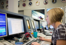 Erin Sholl’s Unforeseen Journey to NASA Spaceflight Safety A woman sits in front of a bank of computer screens in the Mission Control Center at Johnson Space Center.
