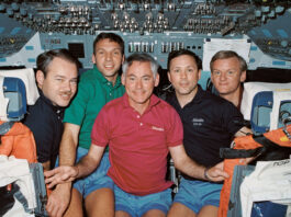 35 Years Ago: NASA’s STS-36 Conducts Defense Mission A group photo of five astronauts wearing different color polo shirts on the flight deck of a space shuttle.