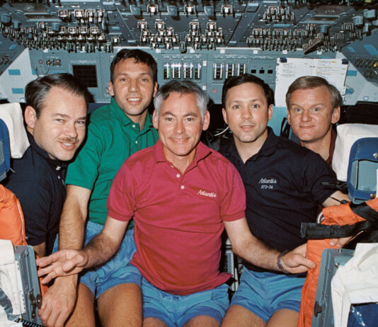 35 Years Ago: NASA’s STS-36 Conducts Defense Mission A group photo of five astronauts wearing different color polo shirts on the flight deck of a space shuttle.