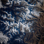 NASA Captures Mount Everest Image from Space A view of Mount Everest and the surrounding area from space. White snow can be seen on mountains; valleys and shadows appear blue-gray.