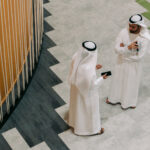 TAMM revolutionizes Abu Dhabi government services with AI innovation Two men in traditional Emirati clothing talking as seen from above.