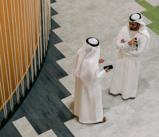 TAMM revolutionizes Abu Dhabi government services with AI innovation Two men in traditional Emirati clothing talking as seen from above.