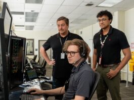 Marshall’s NASA Tools Aid Space Station Operations Three men standing inside a computer room reviewing information on a computer screen.