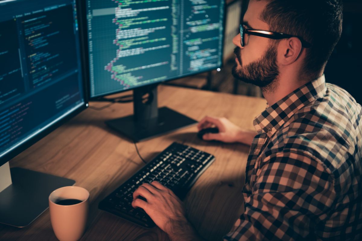 ubunti linux tips Programmer coding on dual monitors at night.