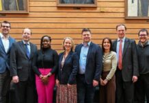Lenovo and University of Southampton Collaborate on High-Performance Computing A line of men and women in business smiling at the camera in front of a wooden background