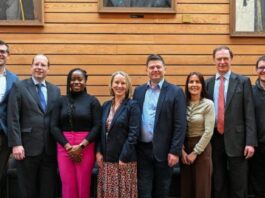 Lenovo and University of Southampton Collaborate on High-Performance Computing A line of men and women in business smiling at the camera in front of a wooden background