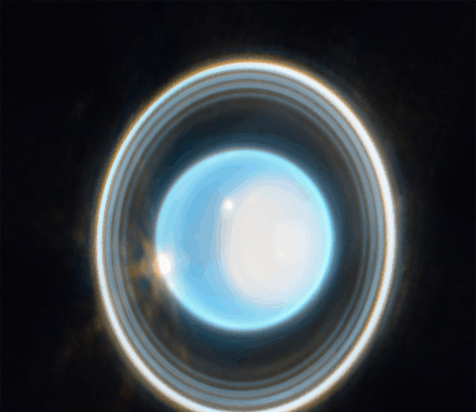 Oxford and NASA Find Uranus Warmer Than Previously Believed A glowing, bright blue-white circular sphere in the center of the image, surrounded by multiple concentric, thin rings of varying brightness against a black background. The rings appear as gray, white, and light-colored bands encircling the central blue-white disc. The outer ring appears brighter than the inner rings, with subtle variations in thickness and illumination throughout the ring structure.