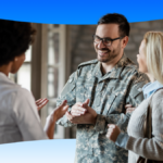 VHA Implements Salesforce OS, Boosting Veteran Care Efficiency. Smiling man in army fatigues discussing care options with woman.