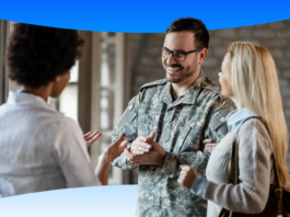 VHA Implements Salesforce OS, Boosting Veteran Care Efficiency. Smiling man in army fatigues discussing care options with woman.