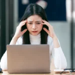 Cloudflare Outage Brings Down Major Websites – Here’s How to Stay Online woman working on laptop having a headache 2024 12 06 08 38 26 utc converted from jpg