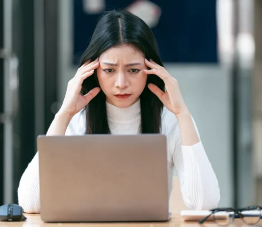 Cloudflare Outage Brings Down Major Websites – Here’s How to Stay Online woman working on laptop having a headache 2024 12 06 08 38 26 utc converted from jpg
